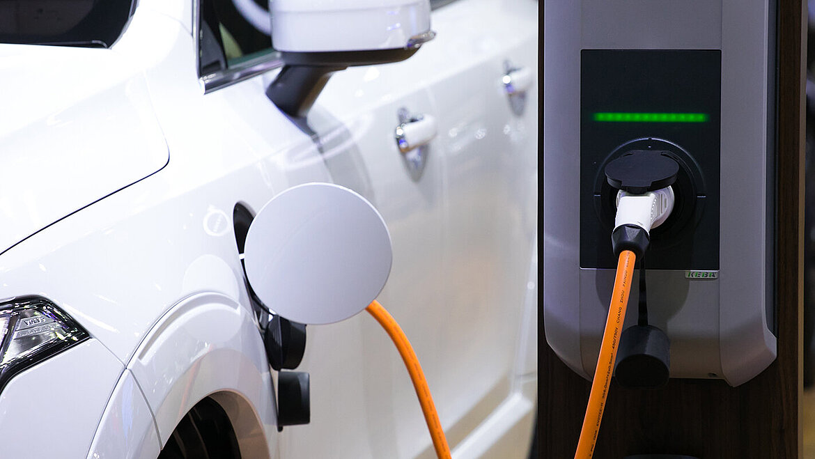 Electric vehicle connected to charging station by cable